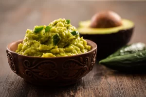 Fresh, creamy bowl of guacamole served at El Mariachi in Rocky Mount, NC, made with ripe avocados, tomatoes, onions, and cilantro.